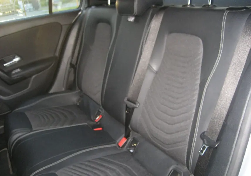 Vue intérieure des sièges arrière en tissu noir avec ceinture de sécurité dans une Mercedes Classe A gris 2021.