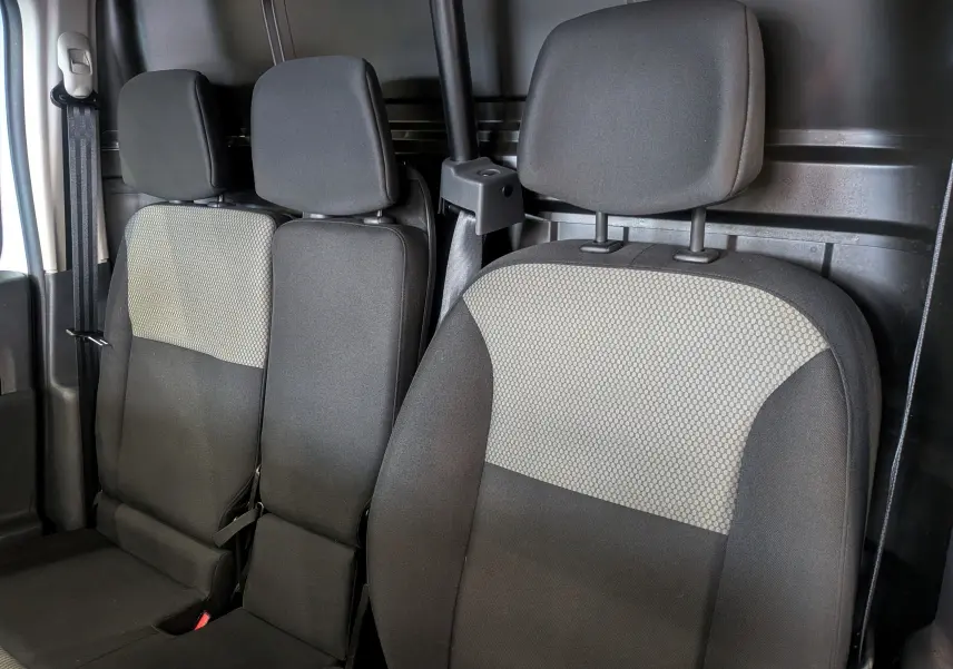 Vue intérieure des sièges avant en tissu gris foncé et clair du Renault Kangoo Express Blanc Minéral, version Blue dCi 95 CH PRO+.