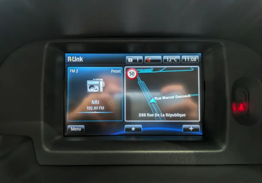 Écran tactile R-Link du Renault Kangoo Express 2020 affichant radio FM et navigation GPS en intérieur.