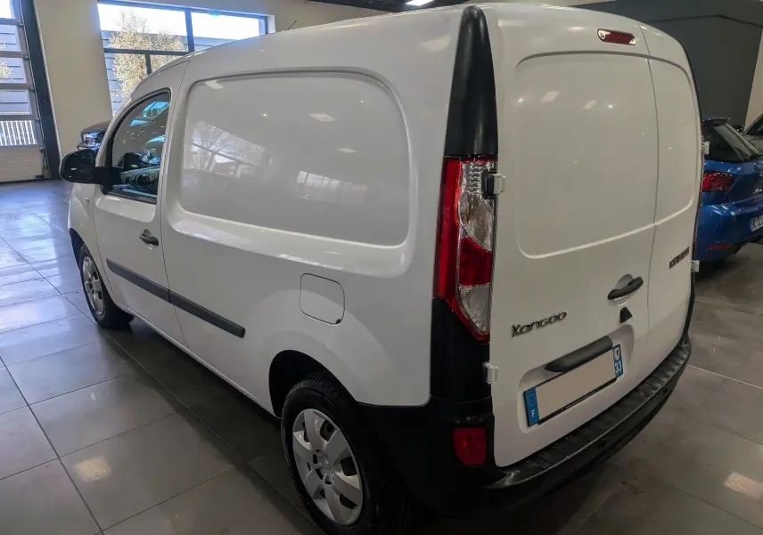 Vue 3/4 arrière droite du Renault Kangoo Express blanc minéral, fourgon utilitaire avec portes arrière pleines en intérieur showroom.