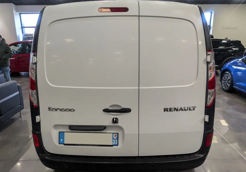 Vue arrière d'un Renault Kangoo Express blanc minéral, montrant les portes battantes et les logos du modèle et de la marque.