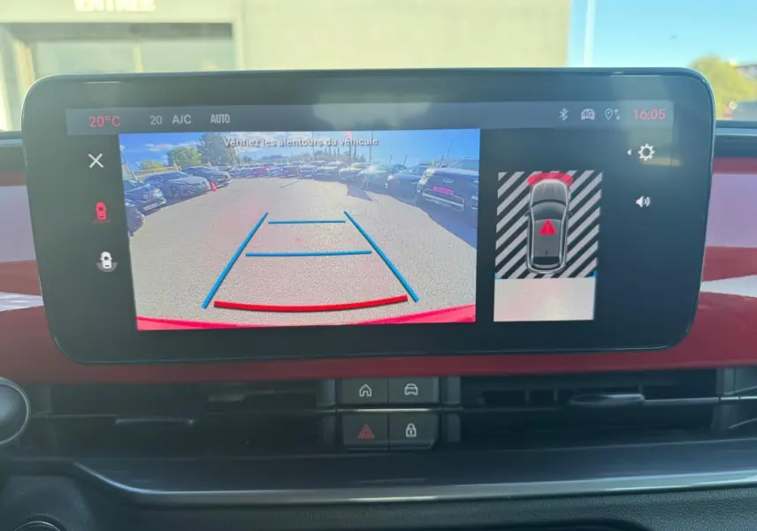 Écran central du tableau de bord du Fiat 600 rouge 2025 montrant la caméra de recul avec lignes de guidage.