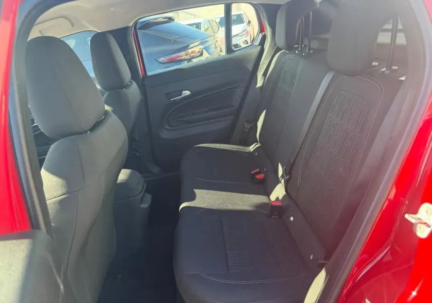 Vue intérieure côté droit des sièges arrière noirs du FIAT 600 T-Gen 3 rouge, avec détails de la porte ouverte.