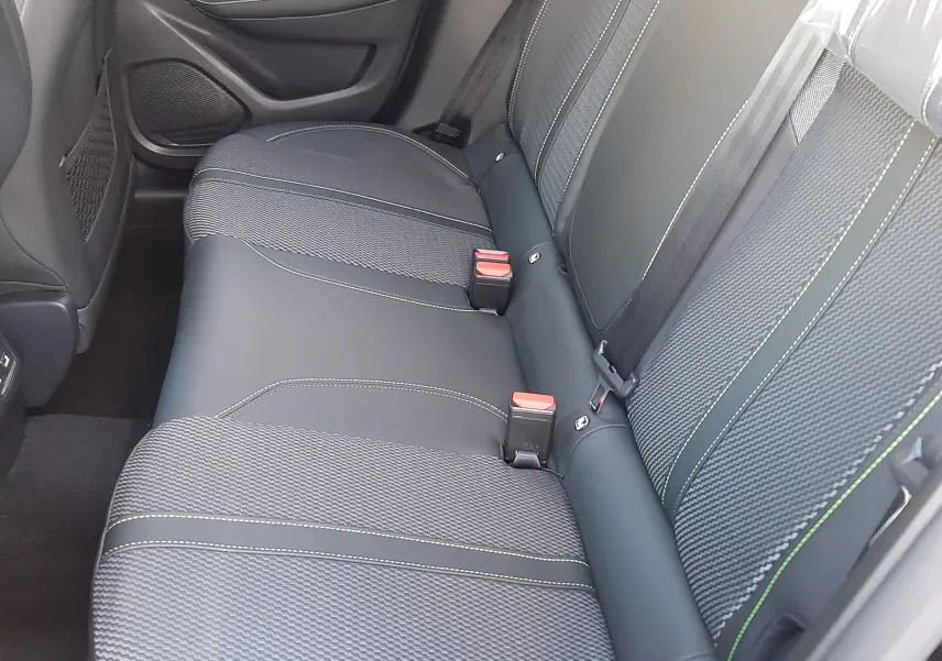 Vue intérieure côté droit des sièges arrière en tissu et cuir noir avec surpiqûres vertes d'une Peugeot 208 Hybrid 145ch GT 2026.