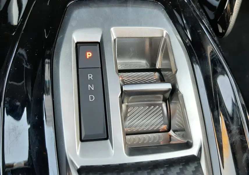 Gros plan sur la commande de boîte automatique noire et argentée du Peugeot 208 Hybrid 145ch GT 2026.