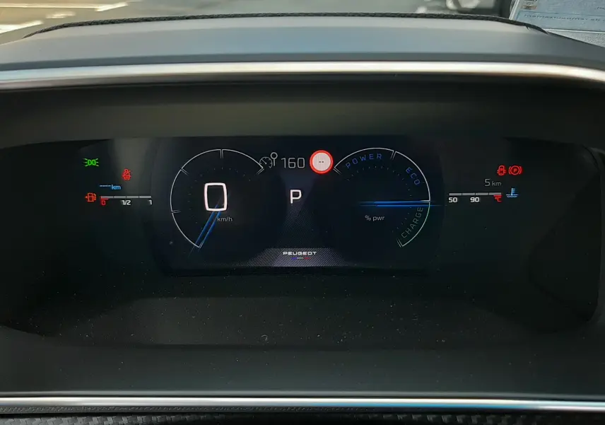 Vue rapprochée du tableau de bord numérique de la Peugeot 208 Hybrid 145CH GT, affichage digital et indicateurs lumineux.