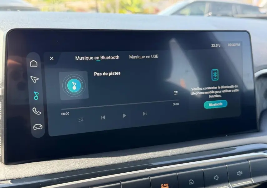 Écran tactile central affichant la musique Bluetooth dans l'habitacle du MG3 blanc, vue rapprochée du tableau de bord.