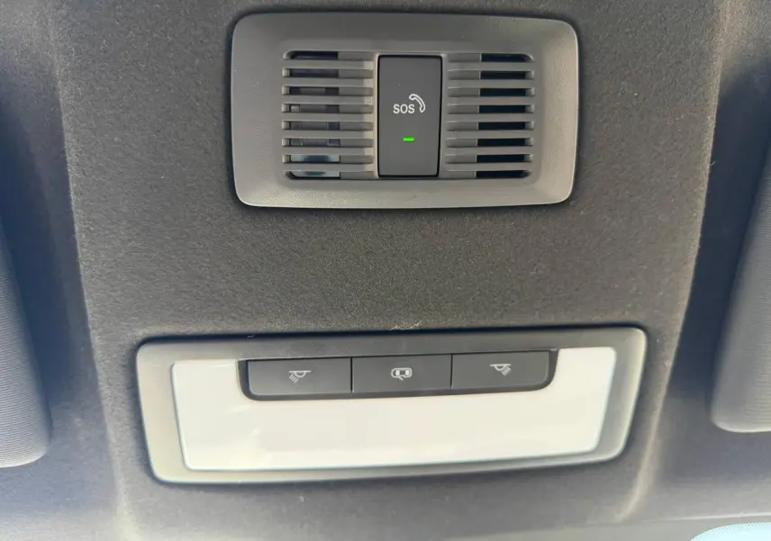 Plafonnier intérieur avec bouton SOS et commandes d'éclairage, vue en contre-plongée dans un MG3 blanc 2025.