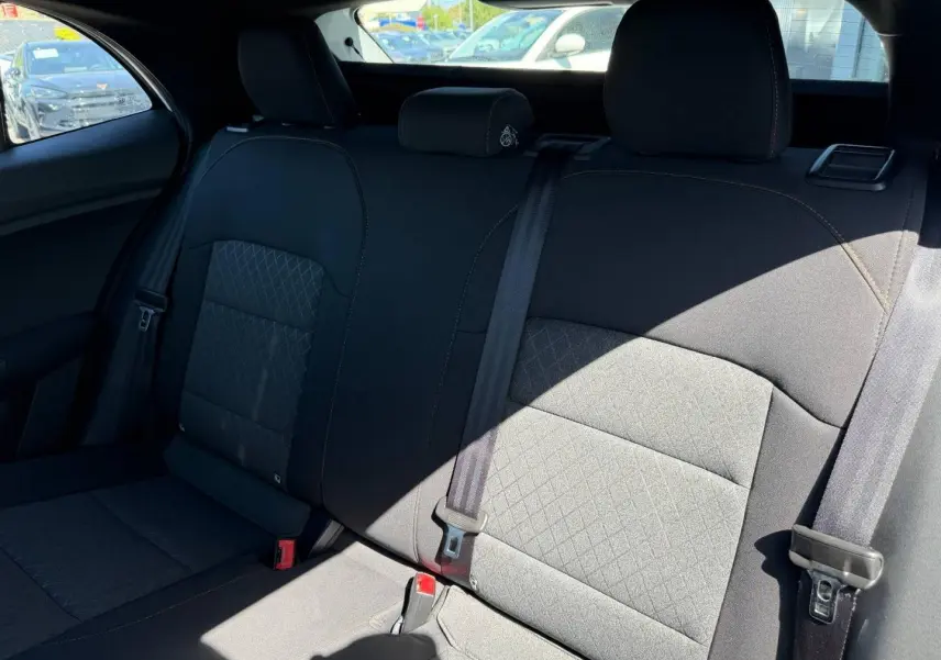 Vue intérieure de la banquette arrière en tissu noir du MG3 1.5 Hybrid+ 195ch Comfort, avec ceintures de sécurité visibles.