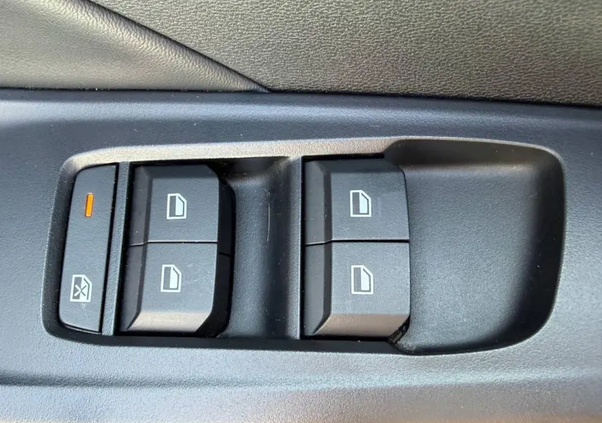 Gros plan sur les commandes électriques des vitres côté conducteur d'une MG3 1.5 Hybrid+ blanche de 2025.