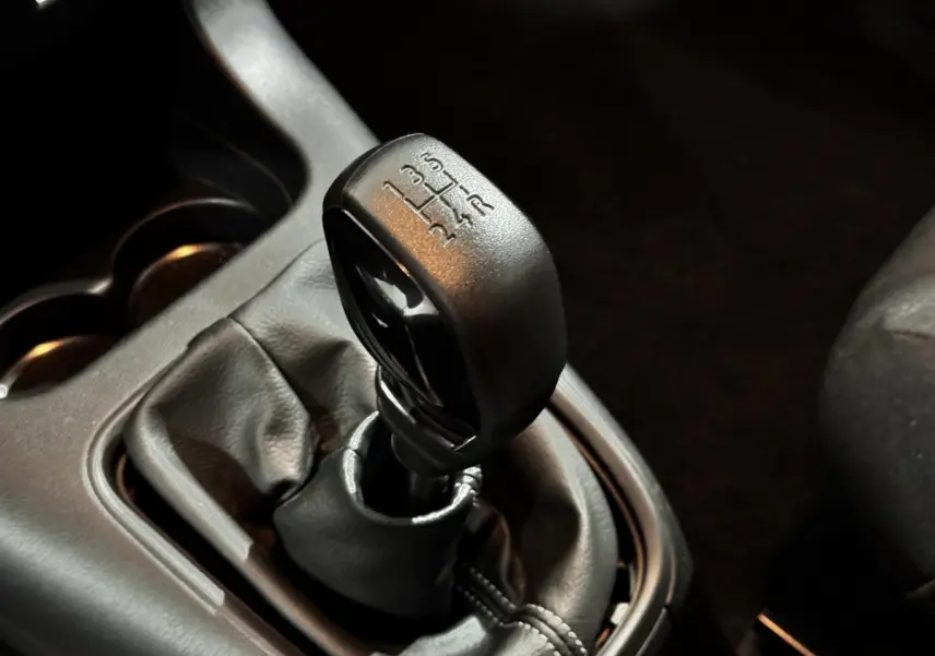 Le levier de vitesses manuel noir de la Citroën C3 PureTech 83 S&S BVM PRO PLUS en gros plan intérieur.