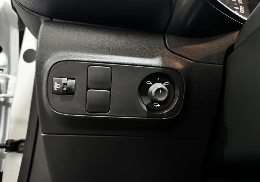Vue rapprochée du panneau de réglage des rétroviseurs et des phares côté conducteur d'une Citroën C3 blanche 2024.