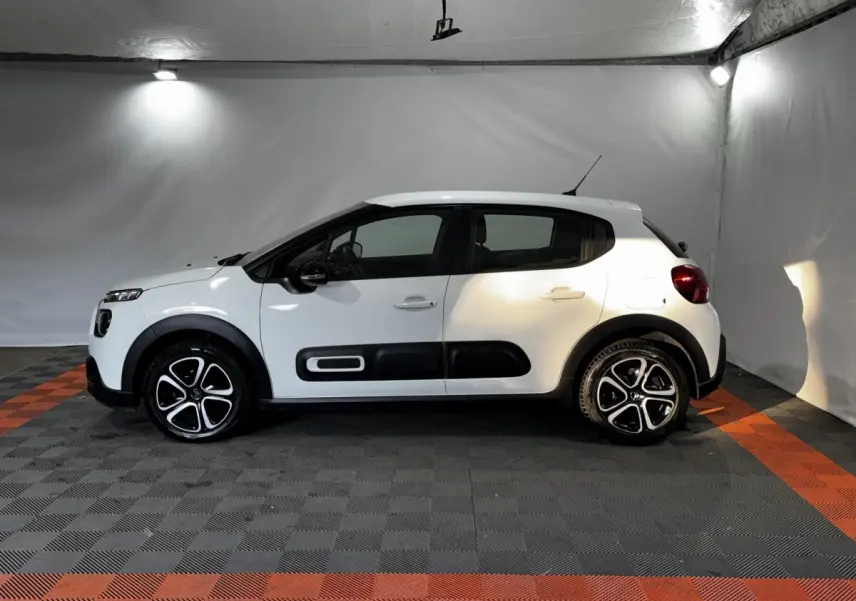 Vue de profil côté gauche d'une Citroën C3 blanche avec protections noires et jantes alliage bicolores.