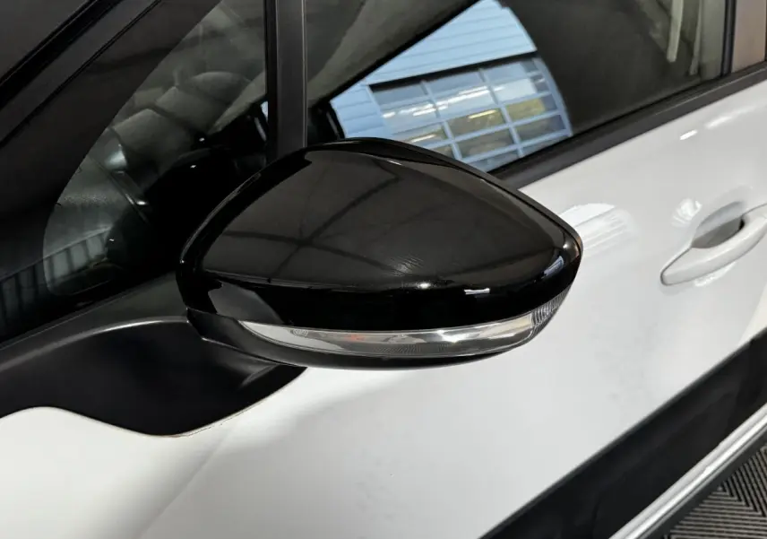 Gros plan sur le rétroviseur droit noir avec clignotant intégré d'une Citroën C3 blanche, vue côté conducteur.