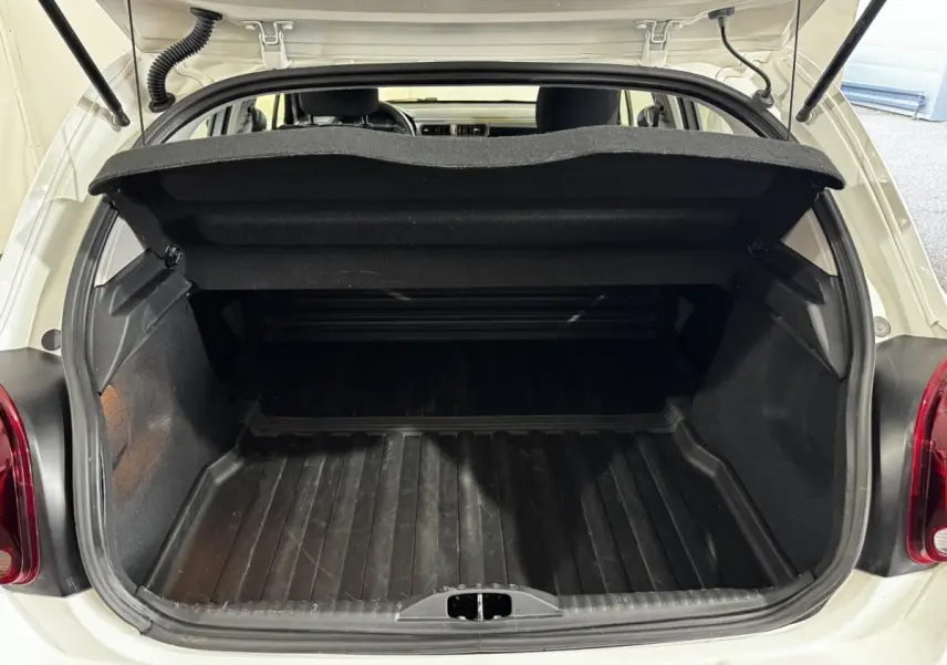 Coffre ouvert vu de l'arrière d'une Citroën C3 blanche 2024, montrant l'espace de chargement vide et la trappe de séparation.