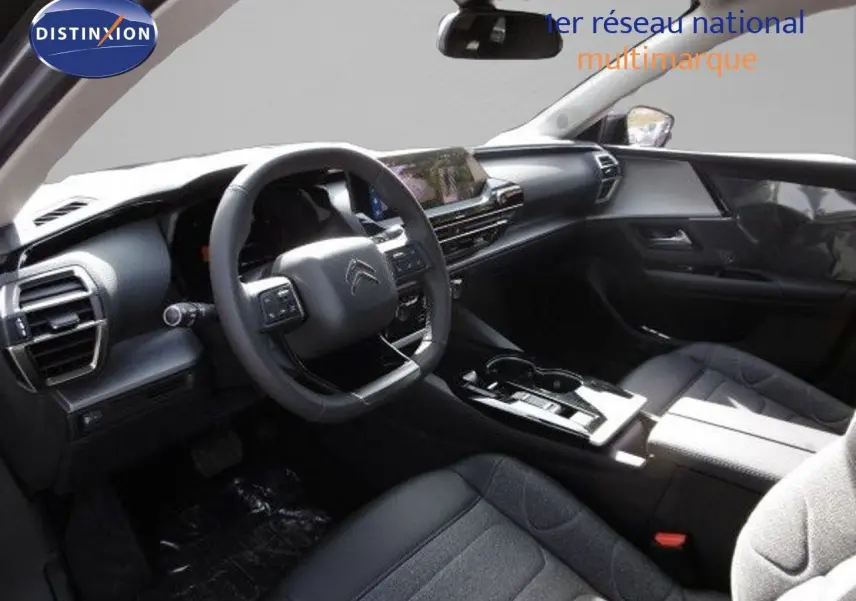 Intérieur noir de la Citroën C5 X 2023, vue côté conducteur avec tableau de bord moderne et volant multifonction.