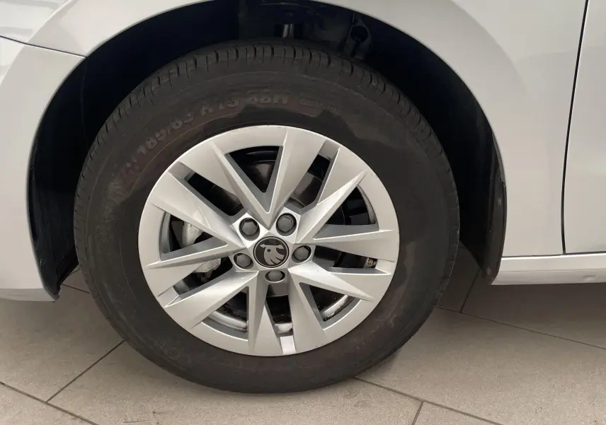 Gros plan sur la roue avant gauche d'une Skoda Fabia gris argent avec jante en alliage au design moderne.