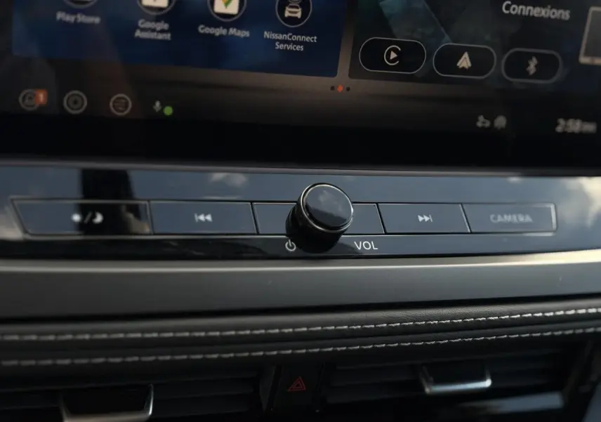 Gros plan sur la molette de volume et les boutons multimédia du tableau de bord du Nissan Qashqai 2024 gris foncé.