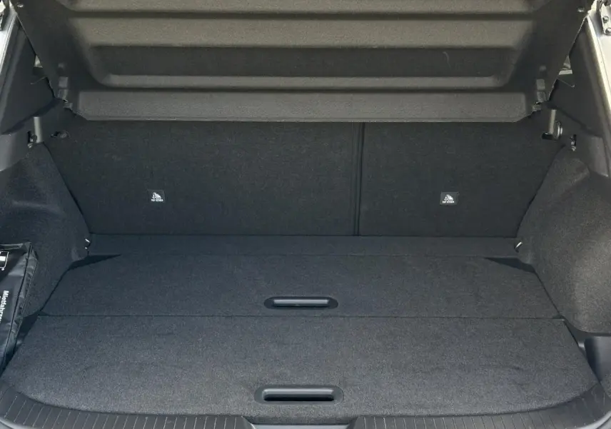 Coffre ouvert du Nissan Qashqai 2024 gris foncé, plancher modulable et hayon électrique visible.