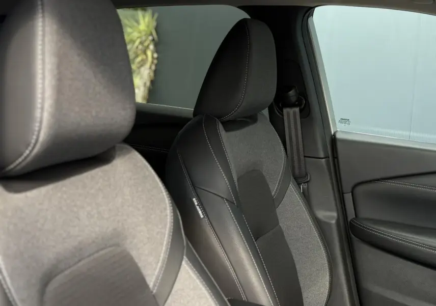 Gros plan sur les sièges avant en sellerie mixte tissu et cuir noir du Nissan Qashqai 2024 côté droit.