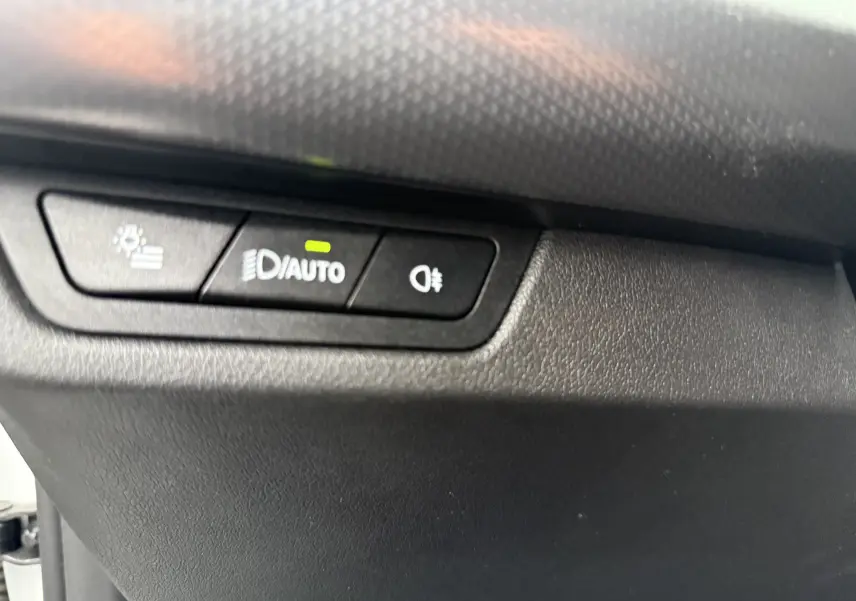 Gros plan sur les commandes des vitres et rétroviseurs côté gauche intérieur d'un BMW X1 blanc Mineral 2025.