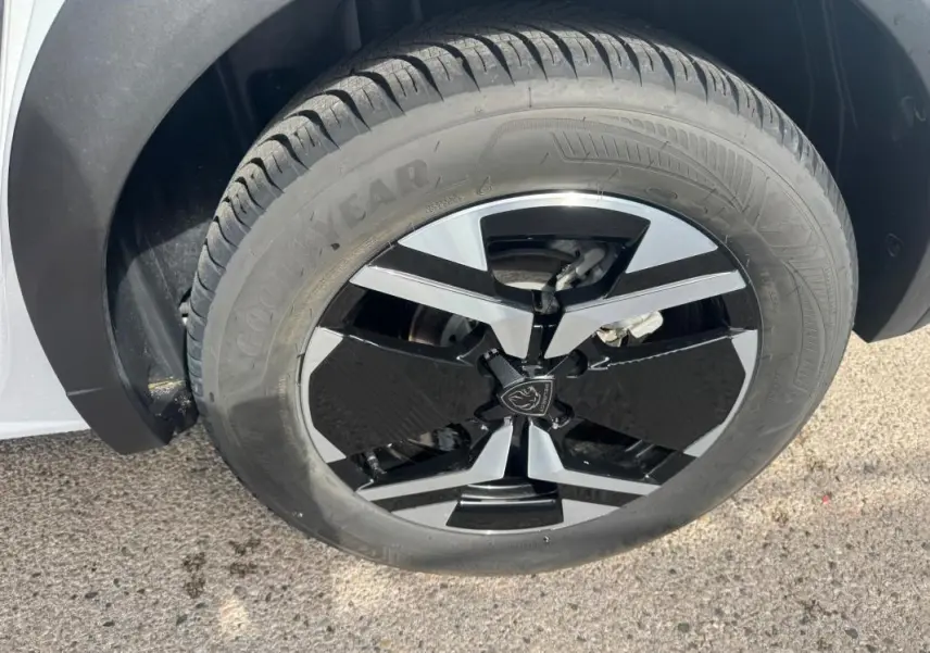 Gros plan sur la jante alliage 17 pouces noire et argentée du côté avant droit du Peugeot 2008 blanc 2024.