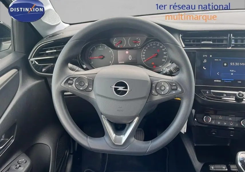 Vue intérieure centrée sur le volant multifonctions d'une Opel Corsa gris 2025 avec tableau de bord et écran tactile visibles.