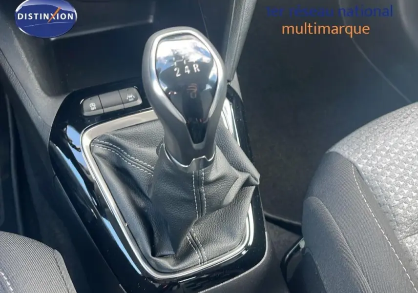 Le levier de vitesse manuel de l'Opel Corsa gris 2025 vu en gros plan avec coutures apparentes et boutons proches.