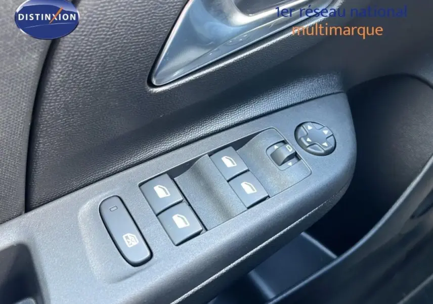 Gros plan sur les commandes des vitres électriques et rétroviseurs sur la porte côté conducteur de l’Opel Corsa gris 2025.