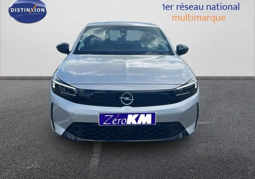 Vue avant d'une Opel Corsa gris clair 2025 avec calandre noire et phares LED, stationnée sur sol goudronné.