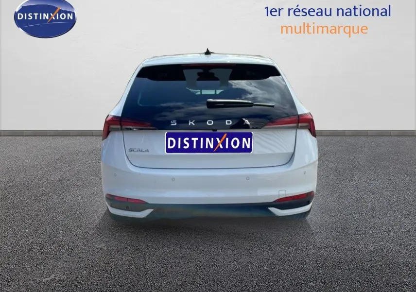 Vue arrière d'une Skoda Scala blanc glacier 2025 avec feux arrière allongés et logo distinctif au centre.