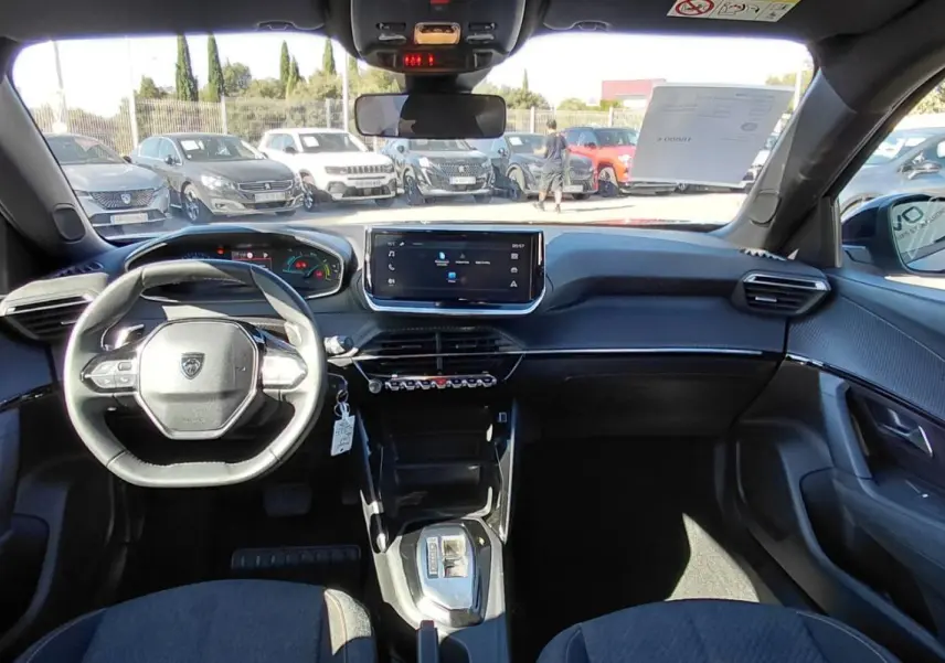 Vue intérieure avant du Peugeot 2008 Hybrid 136 e-DCS6 Style 2025, tableau de bord moderne avec écran tactile et volant compact.