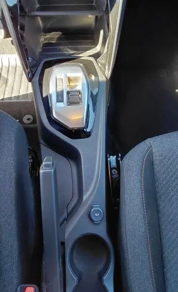 Vue plongeante sur la console centrale noire du Peugeot 2008 Hybrid 136 e-DCS6 Style avec levier de vitesse et porte-gobelets.