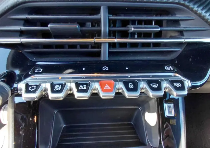 Gros plan sur la console centrale du Peugeot 2008 Hybrid 136 e-DCS6 Style 2025 avec boutons chromés et écran tactile.