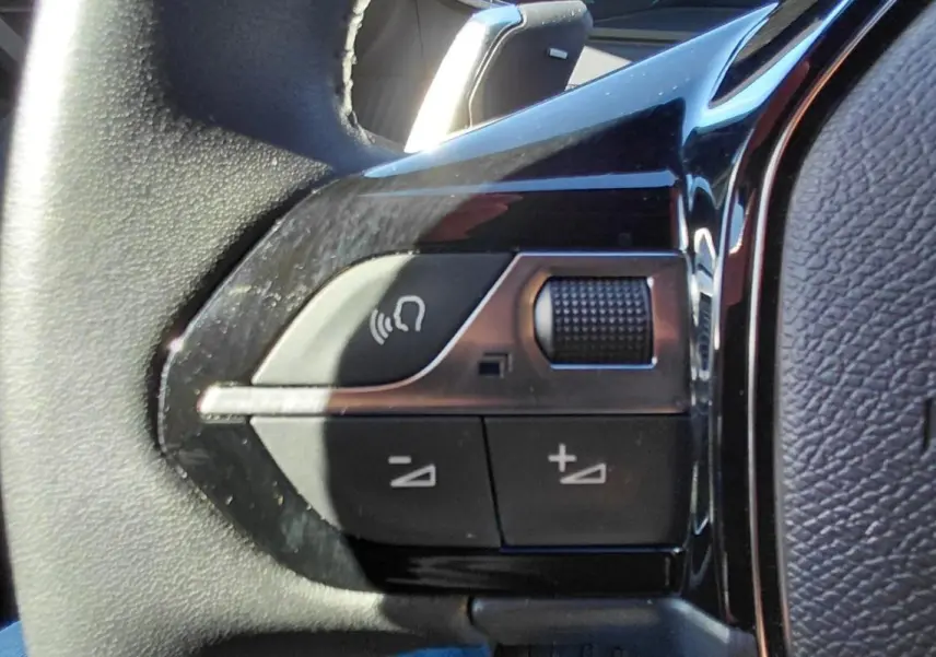 Gros plan sur les commandes vocales et volume au volant du Peugeot 2008 Hybrid 136 e-DCS6 Style 2025.