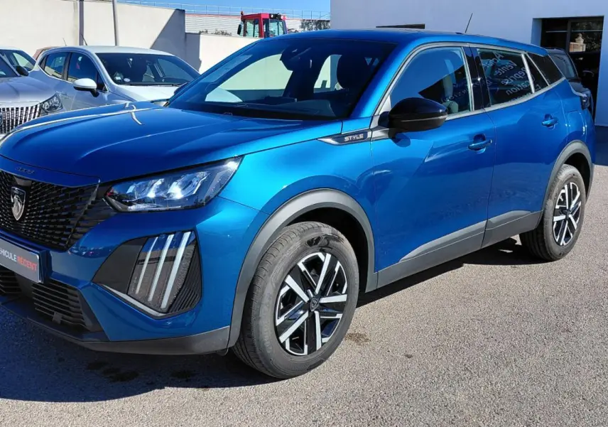 Peugeot 2008 Hybrid bleu en 3/4 avant droit, avec jantes 16 pouces et signature lumineuse verticale distinctive.