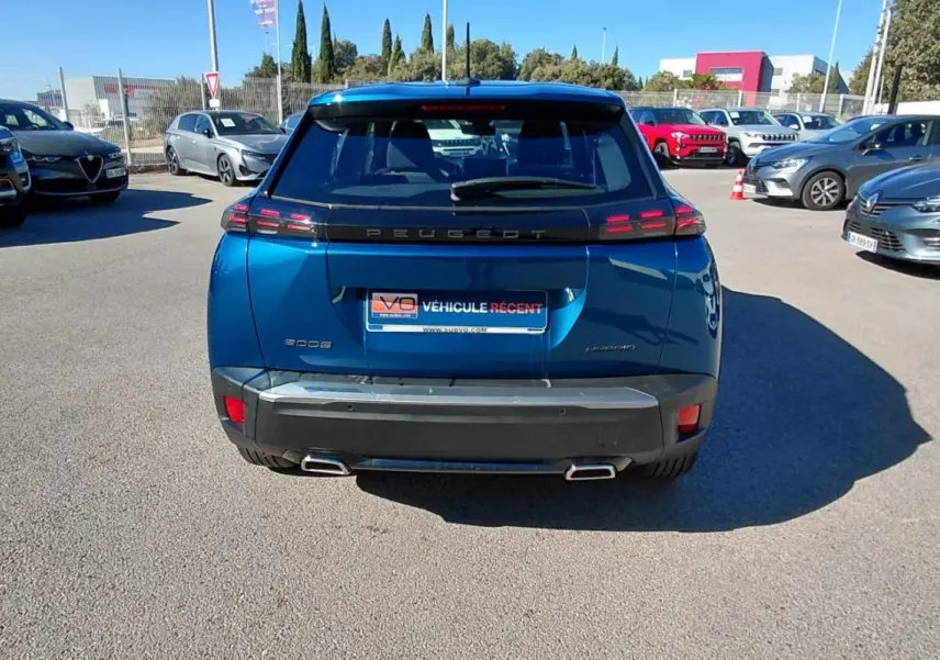 Vue arrière d'un Peugeot 2008 Hybrid bleu 2025 avec feux LED et double sortie d'échappement chromée.