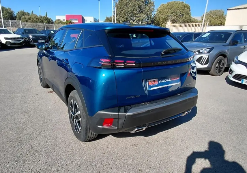 Peugeot 2008 Hybrid bleu en 3/4 arrière droit, avec jantes 16 pouces et feux arrière distinctifs.