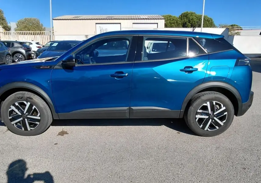 Profil côté gauche du Peugeot 2008 Hybrid 136 e-DCS6 Style bleu 2025 avec jantes 16 pouces et détails noirs contrastants.