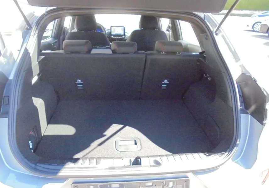 Coffre ouvert d'un Ford Puma gris Solar Metal 2022, vue arrière montrant l'espace de chargement et les sièges arrière.