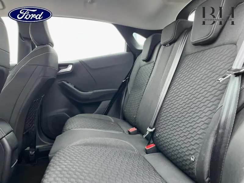 Vue latérale droite de l'intérieur arrière du Ford Puma 2022 avec sièges tissu noir et ceintures grises.