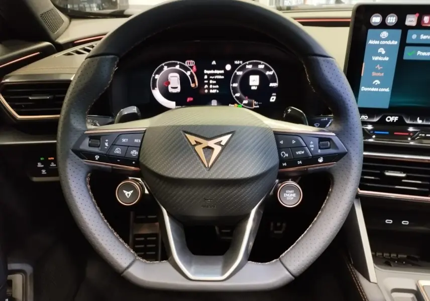 Vue rapprochée du volant cuir perforé noir avec logo CUPRA cuivré et tableau de bord digital du Formentor noir métallisé.