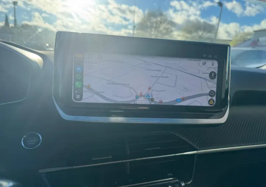 Écran tactile du système de navigation du Peugeot 2008 Hybrid 136 Allure, vue intérieure avant avec lumière naturelle.