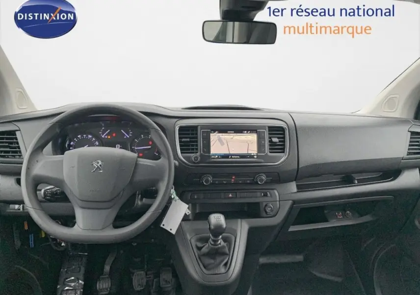 Vue intérieure frontale du tableau de bord noir du Peugeot Expert Fourgon 2023 avec écran tactile GPS et boîte manuelle.