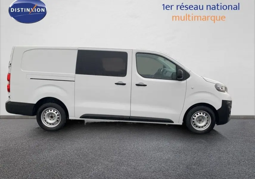 Vue de profil côté gauche d’un Peugeot Expert Fourgon blanc 2023 avec cabine approfondie et vitres teintées arrière.