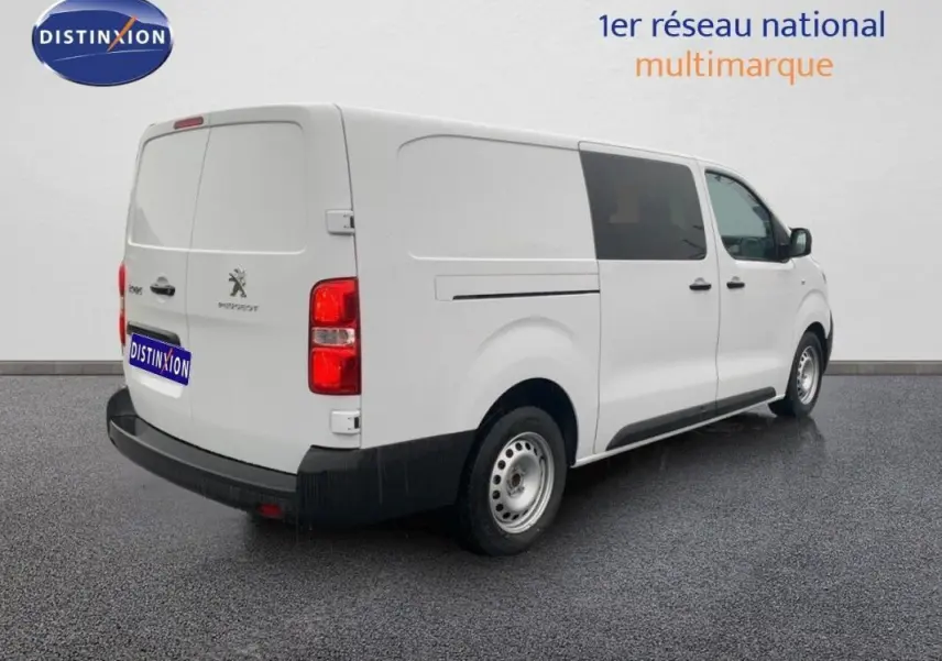 Vue 3/4 arrière droite d’un Peugeot Expert Fourgon blanc, avec portes latérales et arrière fermées, sur sol gris.