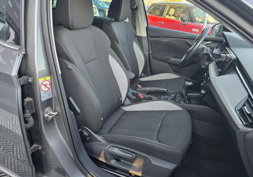 Vue intérieure côté conducteur de la Skoda Scala gris graphite, montrant les sièges avant et le tableau de bord.
