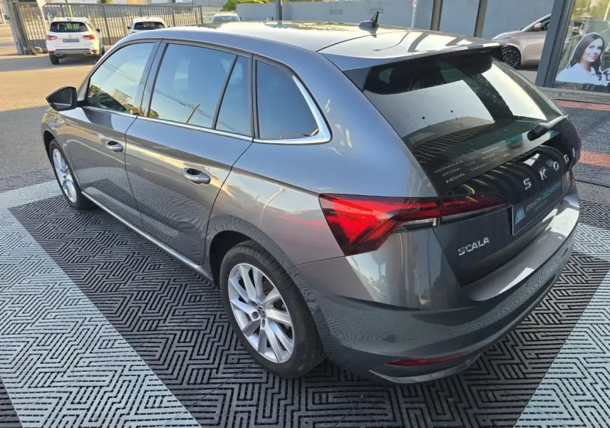 Vue 3/4 arrière droit d'une Skoda Scala 2024 gris graphite métal avec jantes alliage 17 pouces argentées.
