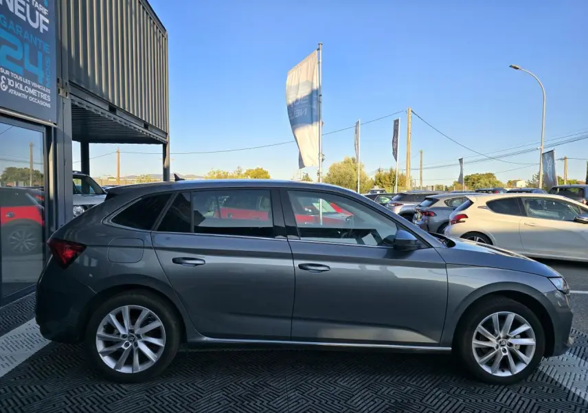 Profil côté gauche d'une Skoda Scala gris graphite métal avec jantes alliage 17 pouces, stationnée en extérieur.