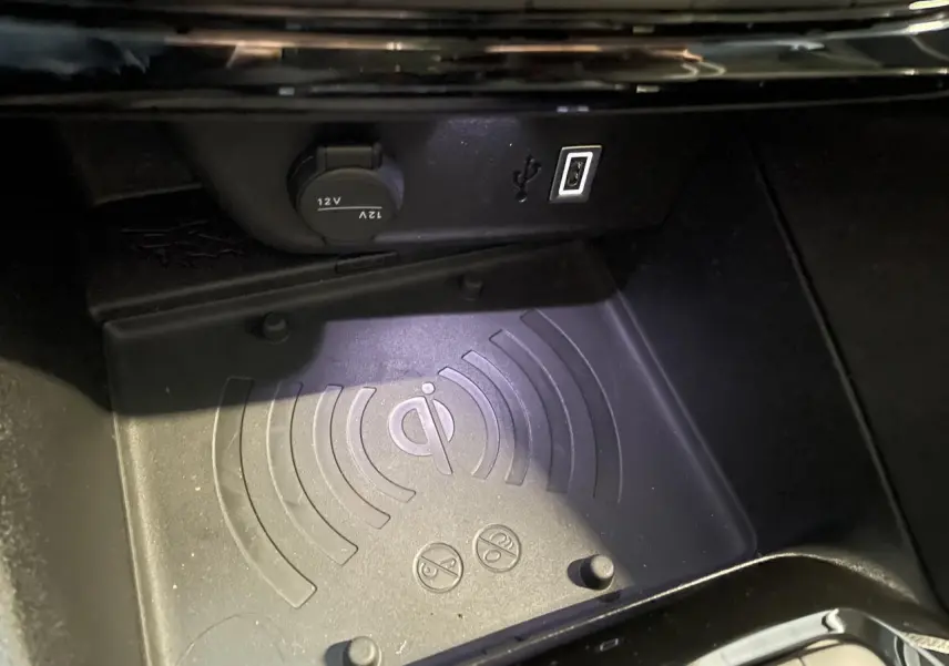 Gros plan sur le chargeur à induction et prise USB dans la console centrale d'une Opel Corsa blanche.